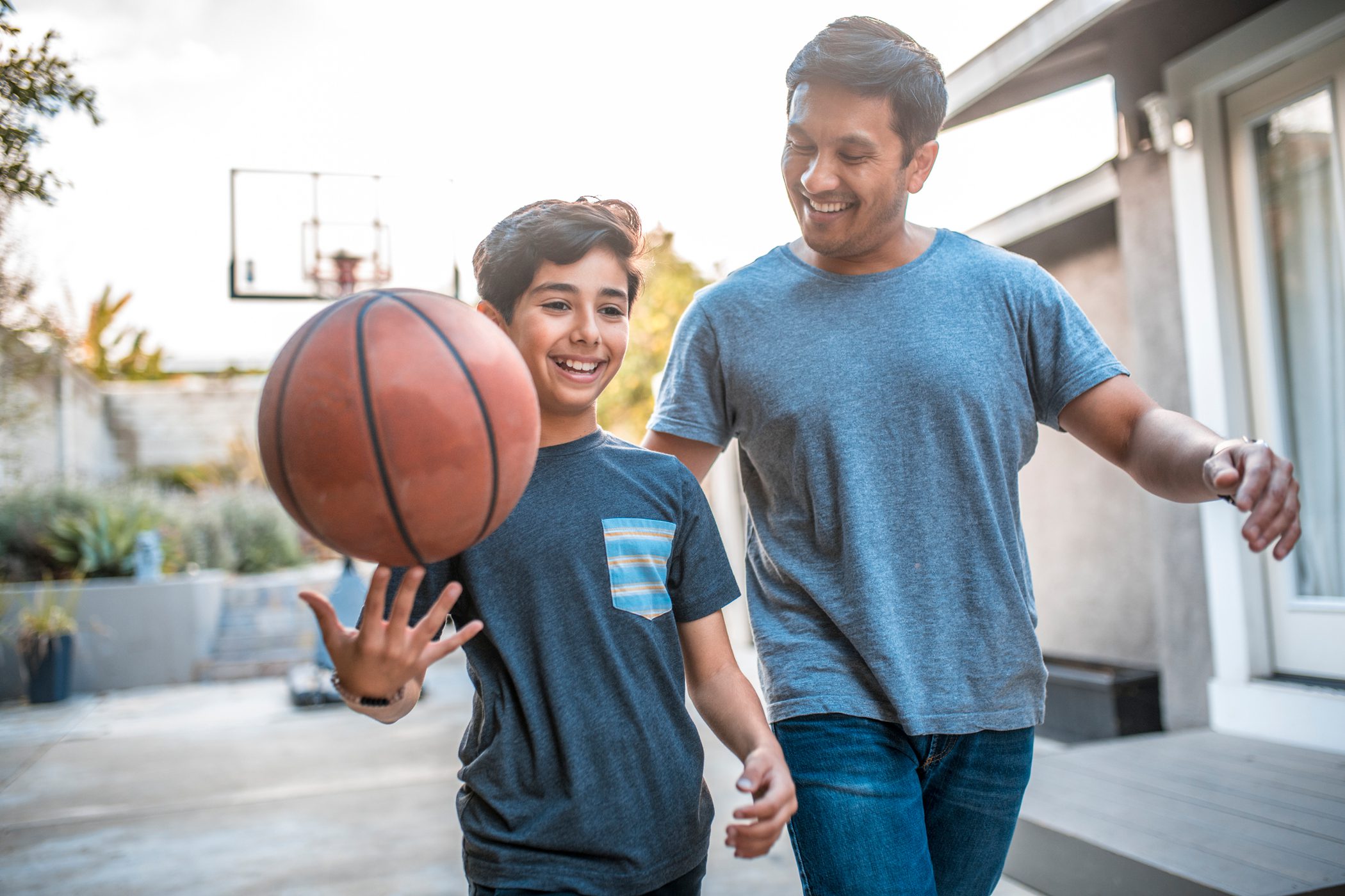 A father and son smile as they prepare to play basketball together