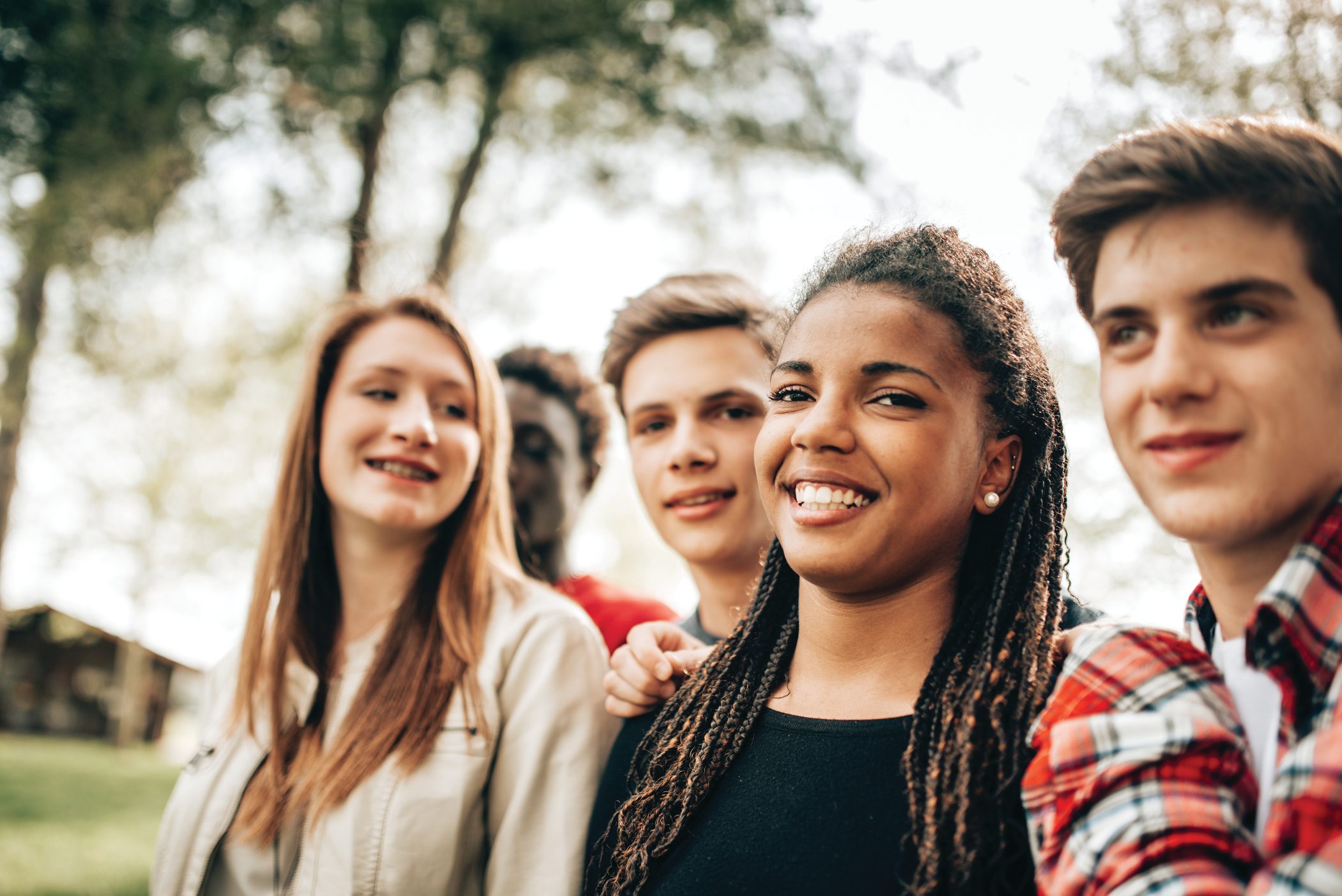 A group of happy teens spend time together in the park
